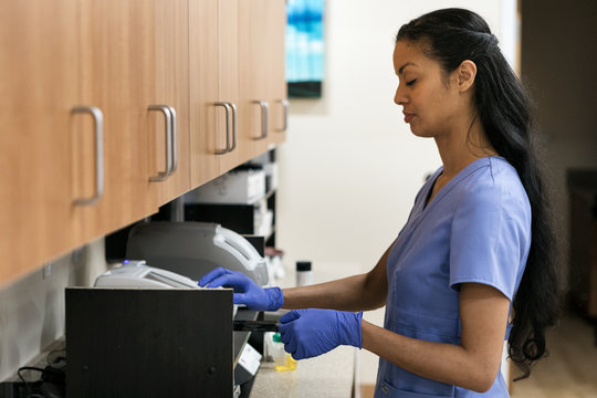 Clinic: Medical Technician Running Test On Urine Sample