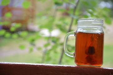 Cup of tea on nature background in a jar of maison with a tea bag