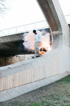 Man riding skateboard in smoke