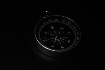 Small pocket compass isolated on black background