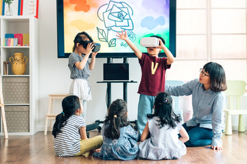 Preshool kids wearing virtual reality headset in classroom