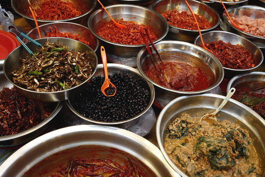 Bowls of Korean kimchi and side dishes in a market