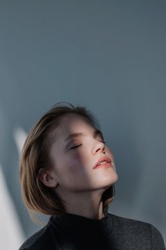 Portrait of pretty blond female posing in contrast daylight