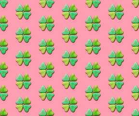 Heart-shaped candies re-arranged in a clover shape on a pink background