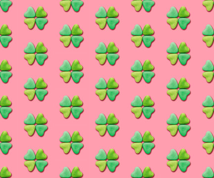 Heart-shaped candies re-arranged in a clover shape on a pink background