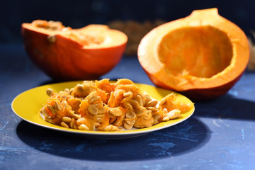 Pumpkin seeds on a plate, blue table
