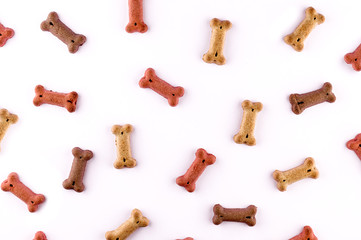 Dog food pattern made with dry snacks in shape of bones. Funny cute flat lay texture. Home pets, animals feeding. Special diet, training supply.
