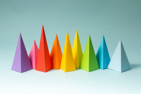 Rainbow pyramid shapes arranged on a bright blue background. (1)