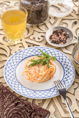 Coleslaw salad with carrot and glass of lemonade on oriental wooden table