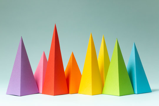 Rainbow pyramid shapes arranged on a bright blue background. (2)