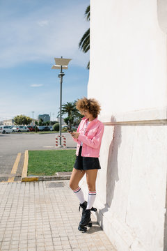 Stylish woman in rollers using phone