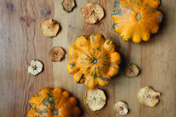 Harvest of yellow squashes with cut dry apples on the table