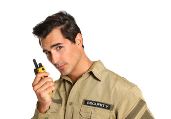 Male security guard in uniform using portable radio transmitter on white background
