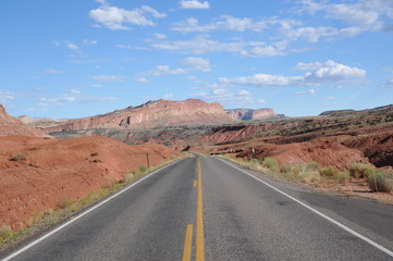 Fototapeta na wymiar Utah highway depicting a long empty road with dramatic landscape