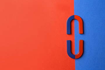 Red and blue horseshoe magnets on color background, flat lay. Space for text