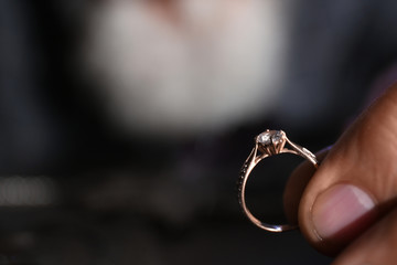 Male jeweler holding diamond ring, closeup view. Space for text