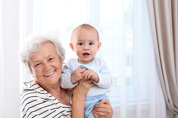 Happy grandmother with little baby at home