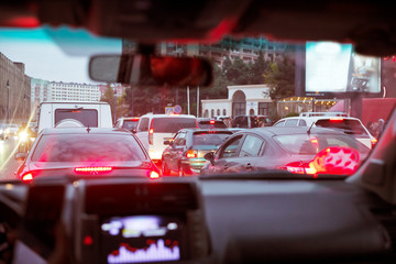 Looking behind the cars.Cars are red, yellow night light. Traffic jams in the city with row of cars...