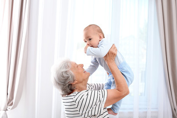 Happy grandmother with little baby at home