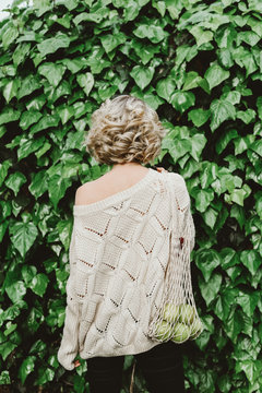 Blonde womam with apples in a net bag