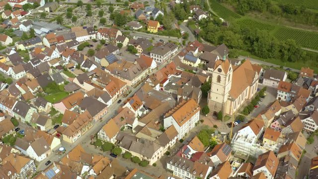 Aerial view of the city Endingen am Kaiserstuhl in germany on a sunny day in summer. Pan to the right around the front of the church.