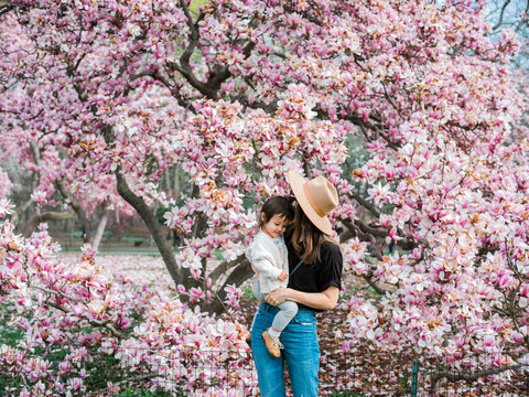 Portrait of mom and baby in front of flower tree