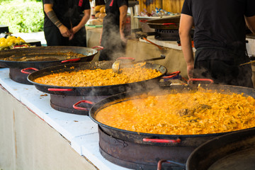 Paella served from paella dishes on a street food festival.