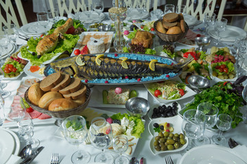 Cooked fish is on the table .Grilled sturgeon fish. Grilled sturgeon fish. Healthy food.bread, sausage, salad. Sturgeon baked with vegetables. Healthy food. grilled fish .