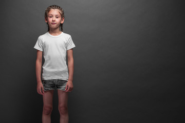 Kid girl wearing white t-shirt with space for your logo or design over gray background