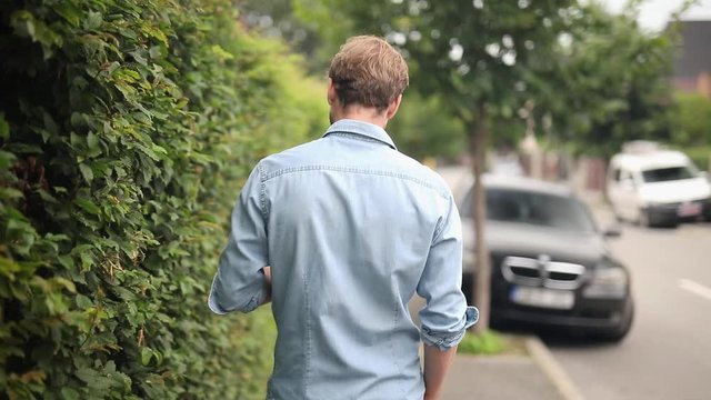 rear view of awalking man that turns and is surprised to meet someon in the street