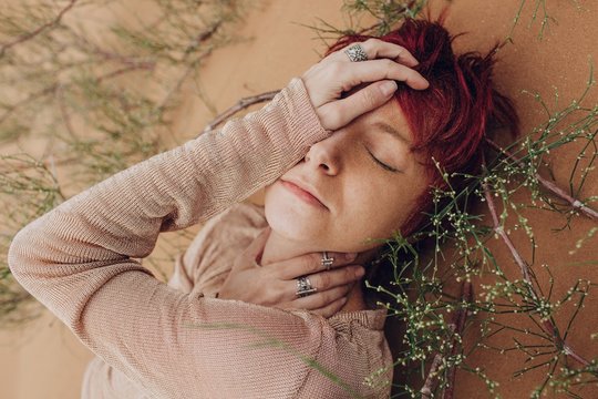 Redhead young woman daydreaming in desert