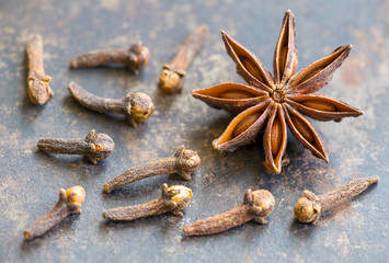 Aromatic christmas holiday spices, star anise and cloves on metal background, decorations