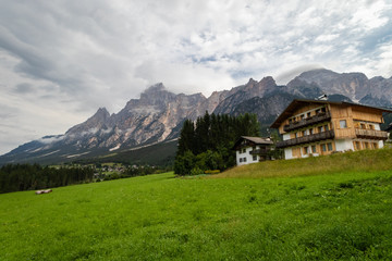 Fototapeta na wymiar Cozy Alpine Buildings in Dolomite Alps mountains in Italy. Cordtina de Ampezzo, Italy