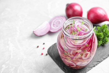 Jar of pickled onions on marble table. Space for text