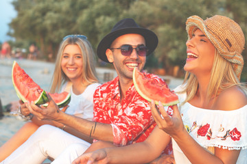 Friendship. People on the beach. Young hipster people eating watermelon on the beach. 