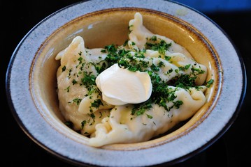 Mordovian style traditional Russian pelmeni dumplings made with minced meat and served with chopped and smetana sour creamdill
