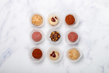 Assorted truffle set  of dark and white chocolate with almonds, hazelnuts and dried cranberries or cherriesin.  Sweet gift. Holiday concept. Copy space, Selective focus