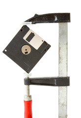A floppy disk caught in carpentry clamps
