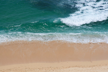 Ocean powerful waves breaking at sand coast