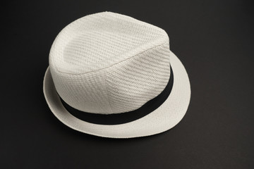 Белая шляпа на черном фоне