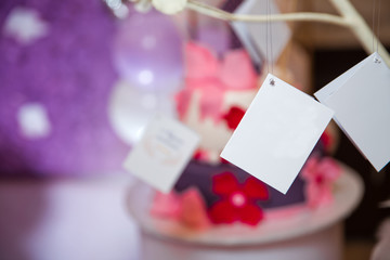 Naklejka na ściany i meble Blank card hanging on string with peg . A sheet of paper on a rope with clothespins on a blurred background .white note . White envelope and beige card hanging on string isolated on blure background .
