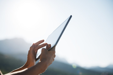 Female hands using digital tablet outside