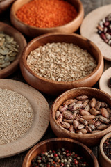 diverse wooden bowls with beans, pumpkin seeds, lentil and cereals