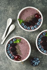Obraz na płótnie Canvas Organic chia seeds smoothie with blackberries, cherries, blueberries and yogurt. Healthy food. Smoothie bowl. Top view. 