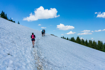 Fototapeta na wymiar People hiking through snow on a mountain