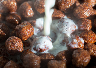 Chocolate cereal balls in milk as food background