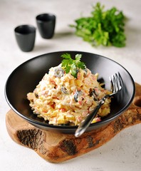 Salad of crab sticks with pineapple, cheese, boiled eggs and olives.