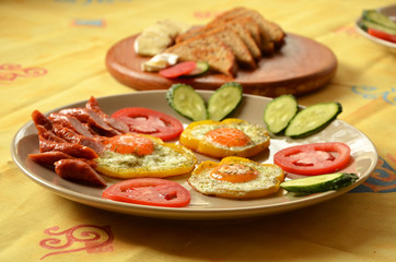 breakfast fried eggs with vegetables and sausages and   croutons  cucumbers tomatoes sweet peppers 