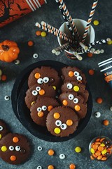 Obraz premium Homemade Chocolate Chip Cookies whith spooky candy eyes for Halloween Party. Halloween background. Top view. 