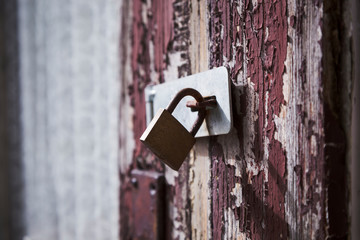 Rusty metal padlock on an old wooden door